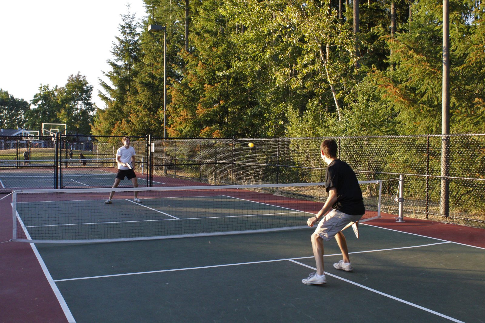 Pickleball doubles action on an outdoor court